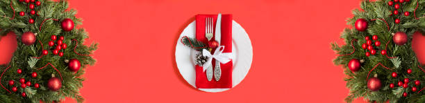 Christmas table setting and ring or wreath on the red background. Copy space. Top view.