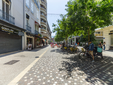 Grenoble, France - July 8, 2023:  Rue de la République with people and bicycles.
