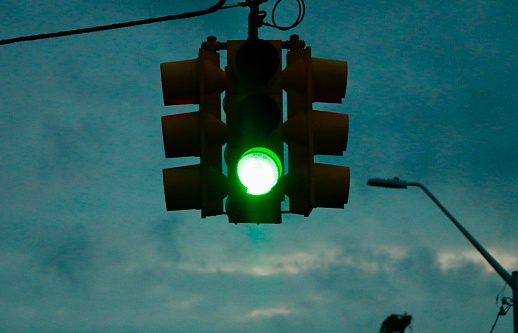 a green traffic light on a stormy evening