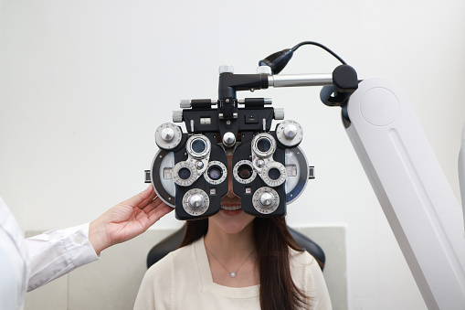 Ophthalmologist inspect and analyze female long sighted vision by Retinoscope