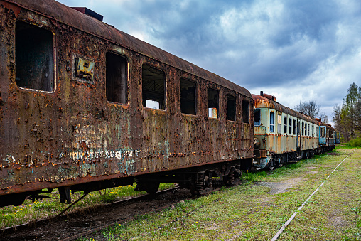 istock Old rusty passenger car with EMUs abandoned on railway tracks 1528666847