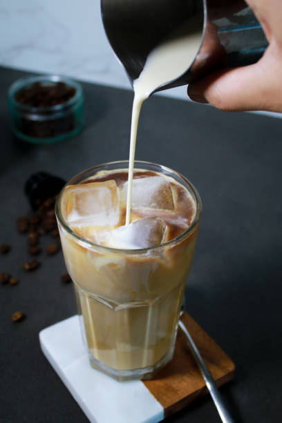 istock Pouring oat milk into cold ice coffee in a tall glass 1528667068