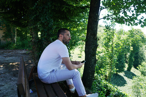 man sitting on bench in green landscape