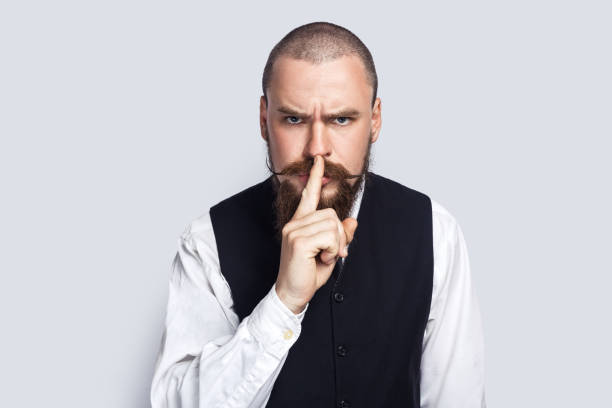 istock Serious strict man standing and showing shh gesture, looking at camera with bossy expression. 1528724724