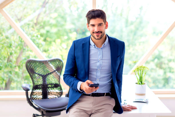 istock Mid aged businessman sitting at office desk and text messaging 1528729405