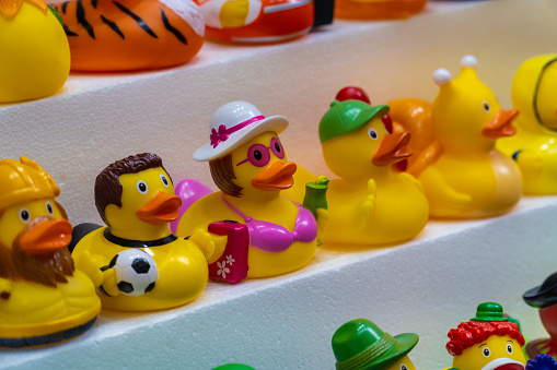 Closeup. Toy rubber ducks with different characterizations, on a store shelf