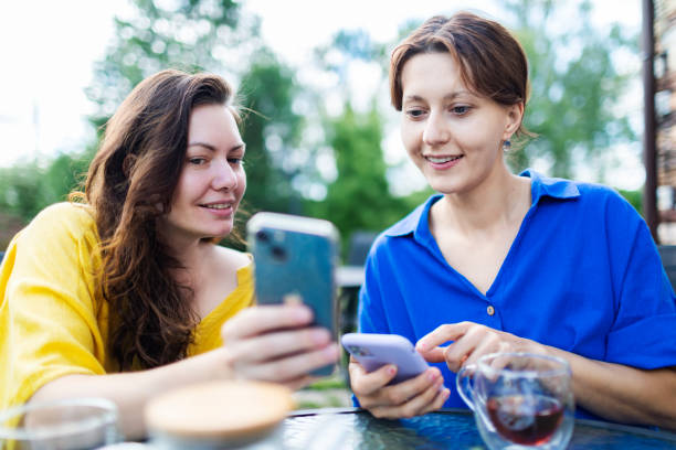 istock Two female friends using their smart technology to transfer payments at cafe 1528778802