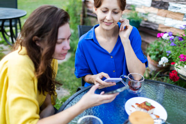 istock Two female friends using their smart technology to transfer payments at cafe 1528784611