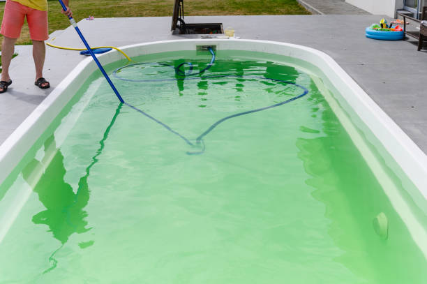 istock Man cleaning bottom of private pool with vacuum cleaner 1528803623