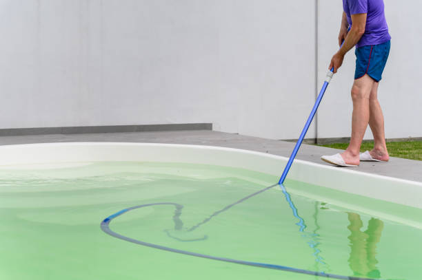 istock Man cleaning bottom of private pool with vacuum cleaner 1528803634