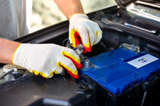 Car battery replacement. the mechanic removes the terminals from the battery case.