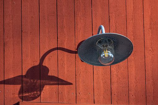Outdoor lamp on a red boat house.