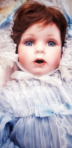 A beautiful doll wearing a blue dress