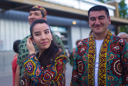 Santa Fe, NM: Smiling Uzbek artists in traditional dress at the Folk Art procession at the Santa Fe Railyard plaza. The procession kicks off the annual International Folk Art Market (IFAM), where folk artists from over 50 countries and tribes participate.