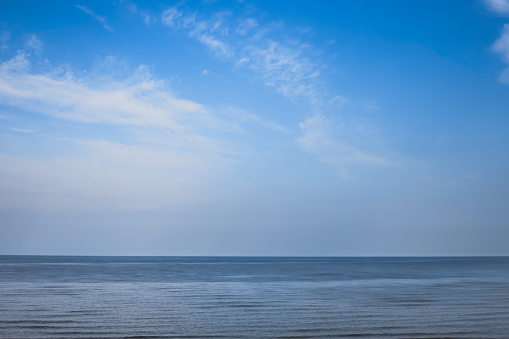 Seascape. Background. Sea, horizon, sky, light transparent clouds. Copy space.