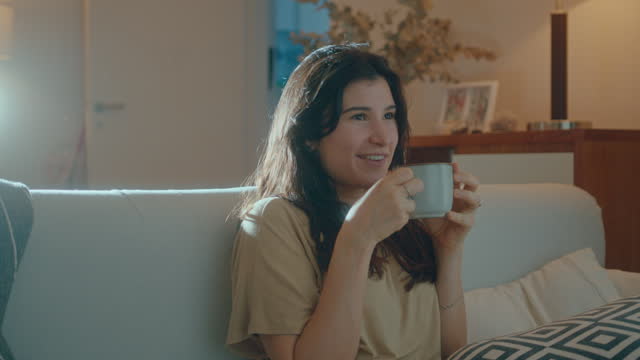 Joyous Woman Watching TV and Drinking Tea at Home