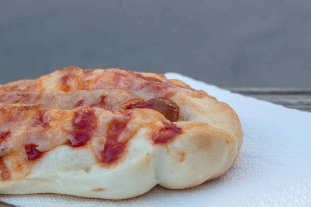 A delicious bun filled with a single sausage and melted cheese, topped with flavorful tomato sauce. Perfect for a quick and satisfying snack or meal.