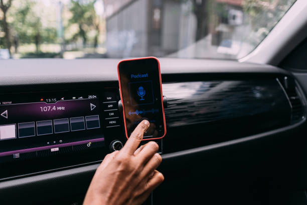 istock Index Finger of an Anonymous Woman Setting up a Podcast on her Mobile Phone while Driving 1529009765