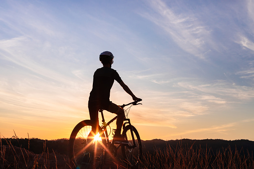Silhouette of a man riding his mountain bike with sunset in the background
