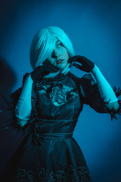 portrait de femme cosplay en costume noir et perruque blanche en studio avec lumière led bleue - manga style fantasy cartoon full length photos et images de collection