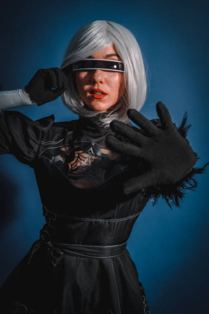 portrait de femme cosplayeuse en costume noir et perruque blanche en studio sur fond bleu - manga style fantasy cartoon full length photos et images de collection