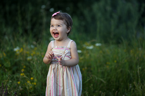 Happy toddler girl smiling outside