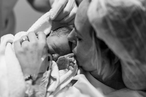 Mother holding her newborn baby child after labor in a hospital stock photo