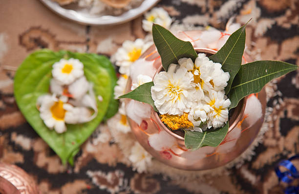 Holy vessels made of copper with other Hindu ritual objects such as flowers for preparation of an Indian Puja.