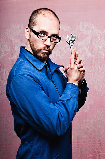 Sexy bizarre repairman holding wrench with humor stock photo