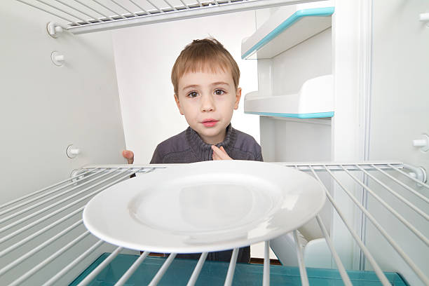 Boy and Empty Refrigerator stock photo