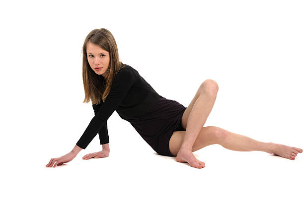 very young charming barefooted woman sitting  on white background