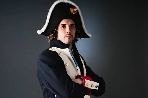 Young adult looking at camera with a Napoleon costume suit.