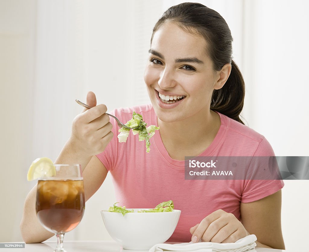 Young Woman Eating Young woman eating green salad. Horizontally framed shot. 20-29 Years Stock Photo