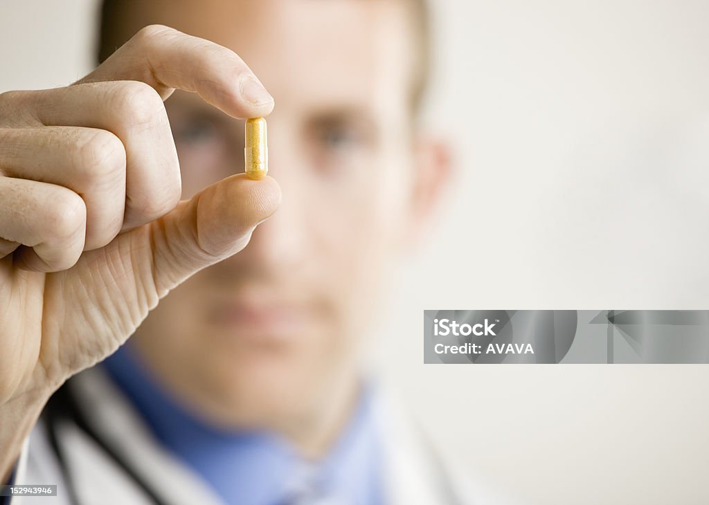 Young Male Doctor Young male doctor holding medication. Horizontally framed shot. Medicine Stock Photo