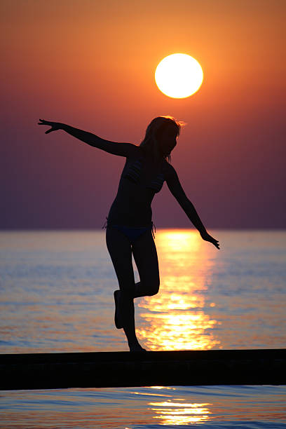 Girl on bridge against sunset. stock photo