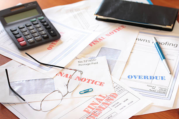 Unpaid Bills on Table with Calculator stock photo
