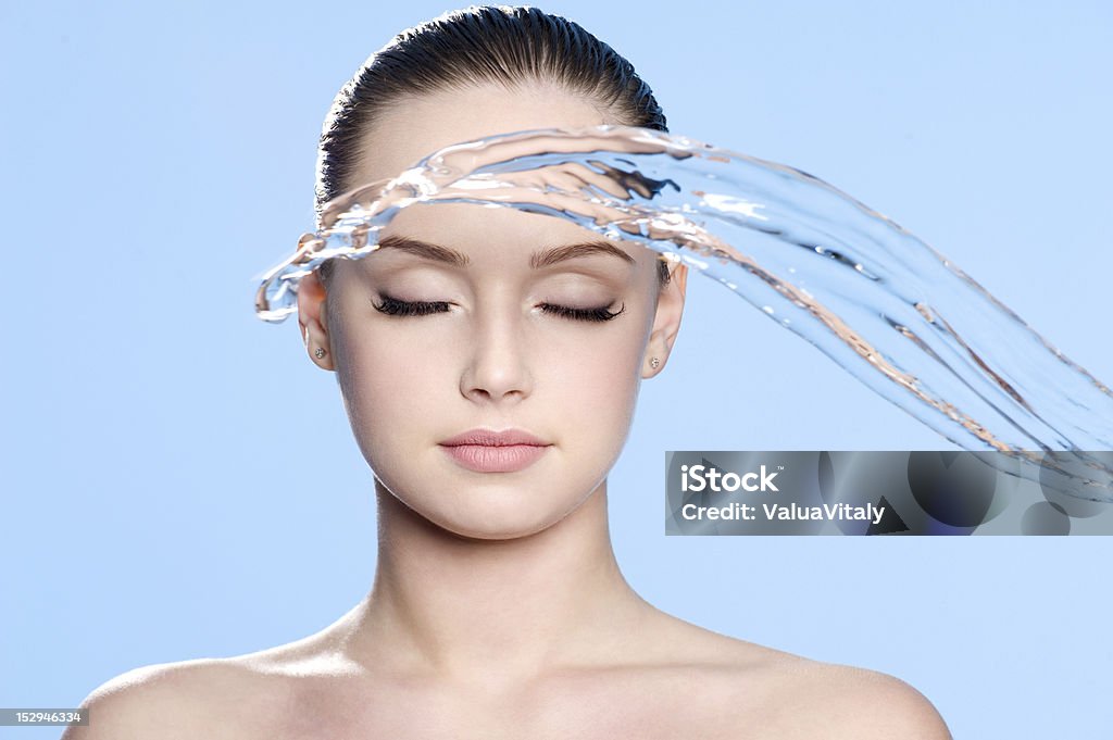 Stream of water before face Stream of clean water before beautiful face of young teen - blue background Human Face Stock Photo