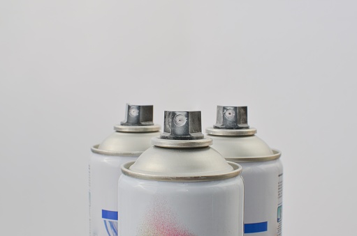 Closeup of white label paint sprays, perfect for creative painting projects and concepts.