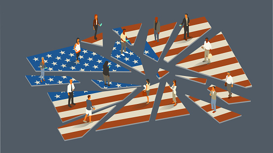 14 contemporary people stand on the pieces of a shattered United States flag, with some of them using mobile devices, in this conceptual illustration representing challenges faced by the country. Vector image presented in isometric view on a 16x9 artboard.