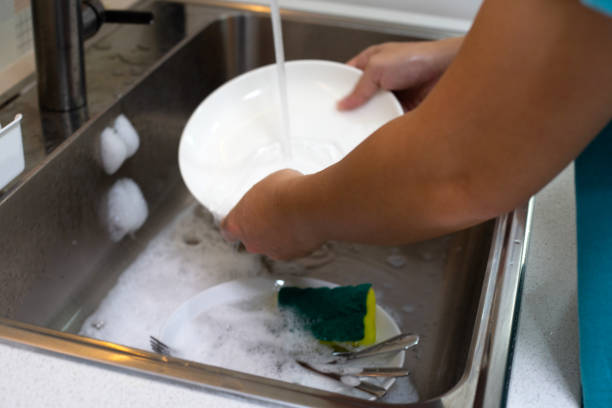istock Man washing dish on sink in kitchen room 1529489286