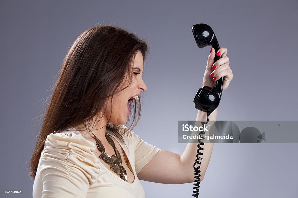 Angry mujer pateando para el teléfono - Foto de stock de Descontento libre de derechos