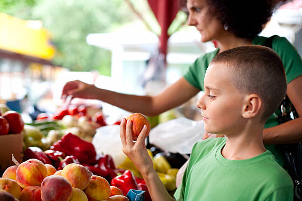 ragazzo carino acquisto di verdure - market farmers market agricultural fair child foto e immagini stock