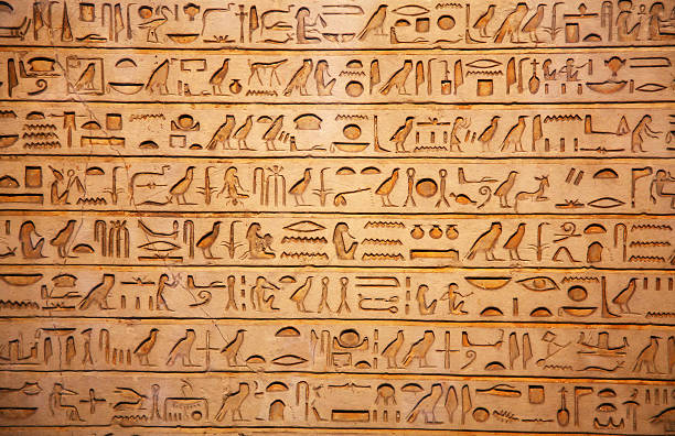 A tan background of old Egyptian hieroglyphics old egypt hieroglyphs carved on the stone hieroglyphics photos stock pictures, royalty-free photos & images