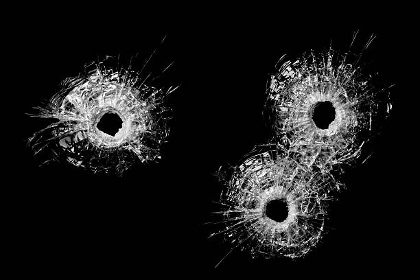 bullet holes in glass isolated on black stock photo