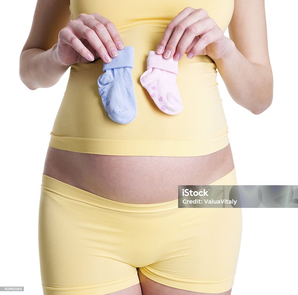 Belly of pregnant woman Belly of pregnant woman close-up and socks for baby - isolated Abdomen Stock Photo