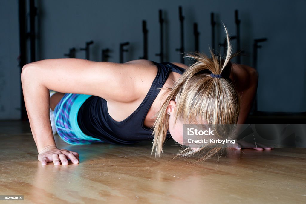 Pushups Beautiful young woman doing a pushup at gym.  Dramatic Lighting. 20-24 Years Stock Photo