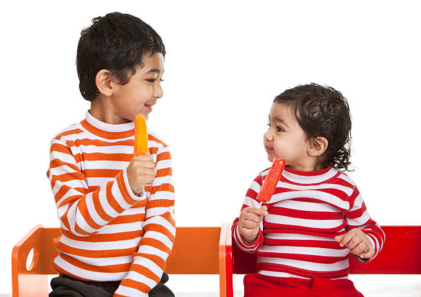 Siblings Enjoying Popsicles stock photo