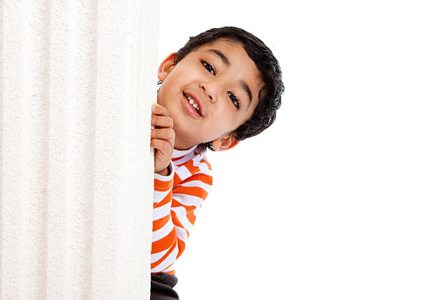 Smiling Toddler Peeks from Behind a Column stock photo