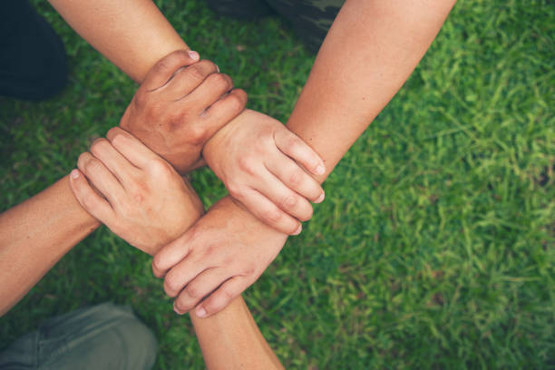 istock Top View Four hands Diverse multiethnic Partner team together. Close up Teamwork group of Four multiracial people join hands together. Above view Diversity people hand join partner team trust team 1529548327