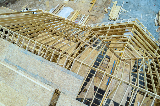 During construction of wooden built home under construction, this construction site on roof beams plywood